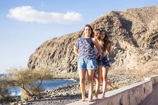Três Jovens Amigas Caminham Juntas Numa Parede Perto Praia Tenerife — Fotografia de Stock