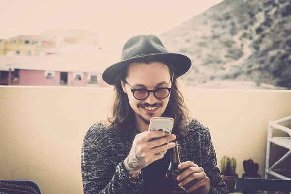 Hosszú Haj Szép Fiatal Ember Olvassa Ellenőrizze Telefon Szabadtéri Tetőteraszon — Stock Fotó