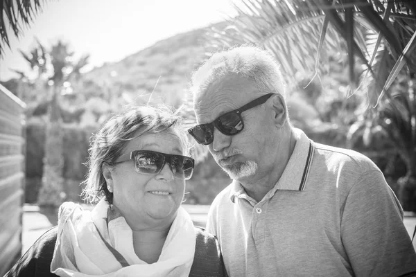 老夫妇与白色头发和太阳镜播放和鬼脸户外在夏季 — 图库照片