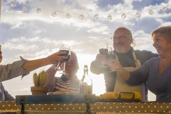 パティオで屋外のワインと成熟した男性と女性の歓声は 祝う休暇や誕生日やイベントのため屋上をテラスします 高齢者生活幸せな日生命概念 — ストック写真