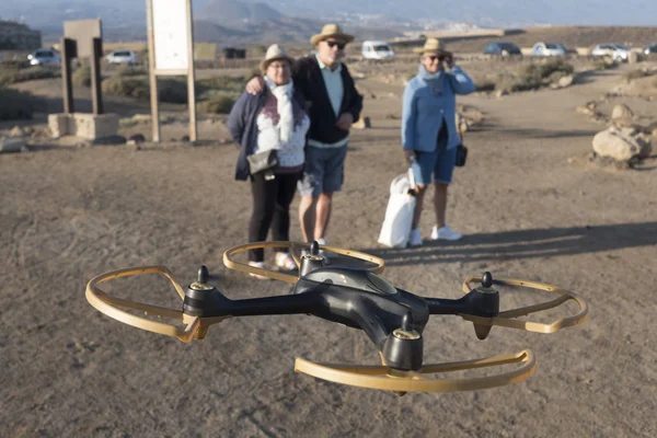 Modern technology drone with three elderly senior. Group looking at flying object in a parking.