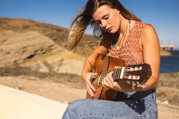 美しい若い女性は 芸術と自由と余暇活動の屋外のアコースティック ギターを演奏します 若い人たちの休暇代替独立の概念 背景の海 — ストック写真
