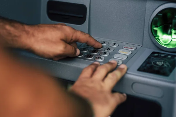 无法辨认的密探手在银行里键入密码取款 — 图库照片