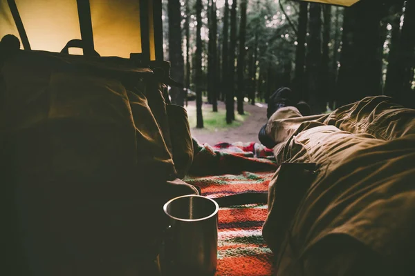 Man legs point of view pov inside a tent with outdoor wild forest outside