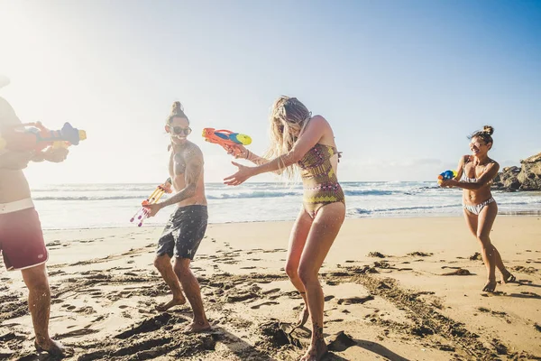 행복하고 즐거운 청소년들이 방학중에 해변에서 싸움을 하면서 친구와 재미있게 — 스톡 사진