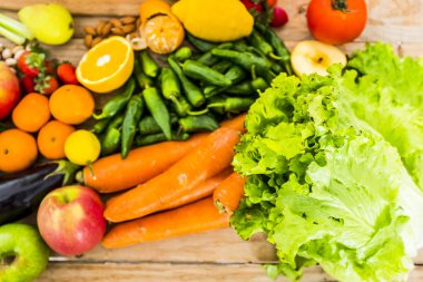 Sağlıklı gıda ve vitamin kavramı olan ahşap bir masada karışık ve renkli mevsimlik sebze ve meyvelerin kapanışı vegan ya da vejetaryen beslenme yaşam tarzı