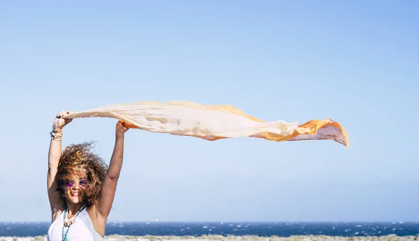 快乐快乐的 快乐的高加索女青年与蓝天 大海背景的风和橙色纺织品玩耍 人们在旅游和度假活动中的自由和快乐的概念 — 图库照片