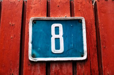 Sekiz numara, ev işareti olarak mavi ve kırmızı renkler ve ahşap arka plan malzemesi. 