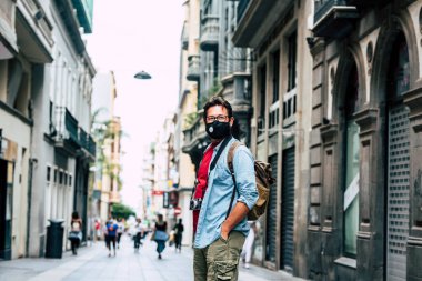 Coronavirus salgını sırasında turizm ve turizm - kamera teçhizatı ve sırt çantasıyla ayakta duran adam şehrin sokaklarının keyfini çıkarın 