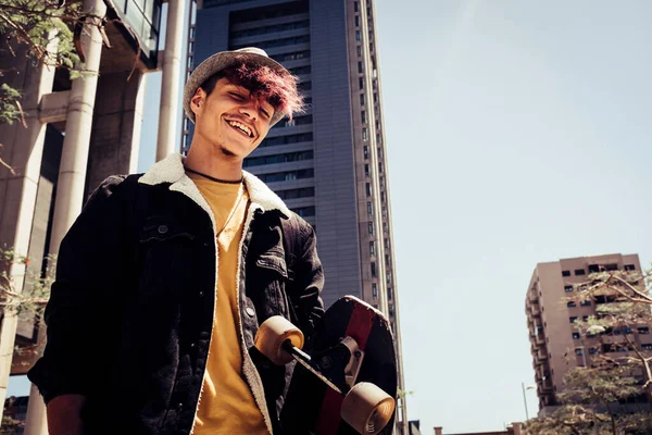 Urban style generation z young teenager portrait with city skyline in background - alternative and diversity people concept with handsome coloured hair male