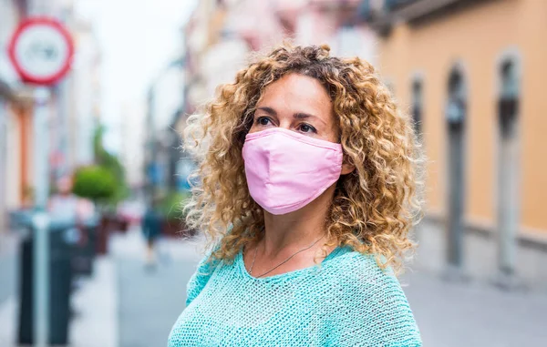 Güzel yetişkin kadın portresi Coronavirus covid-19 sağlık durumu sırasında koruyucu maske takar.