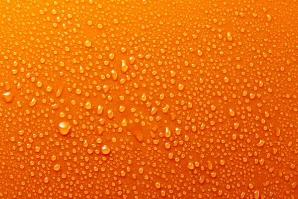 Gotas de água no fundo laranja textura escuro — Fotografia de Stock