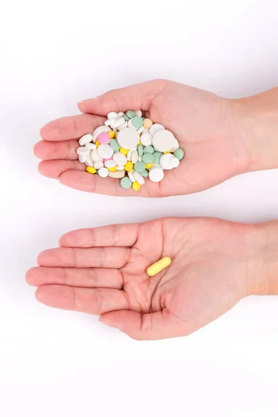 Fotografie z rukou s mnoha pilulky a jedna kapsle zlata — Stock fotografie