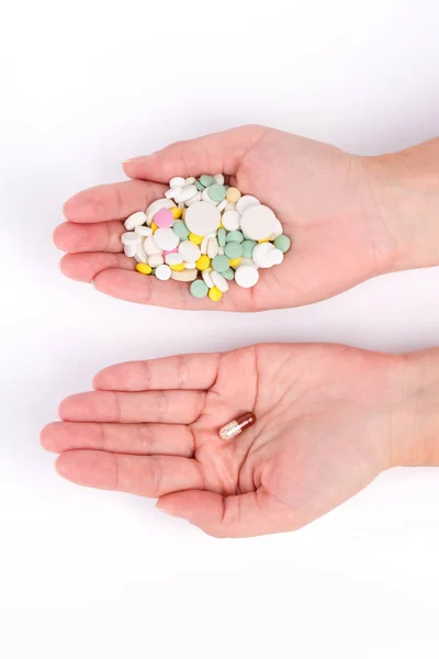 Fotografie z rukou s mnoha pilulky a jednu tobolku — Stock fotografie