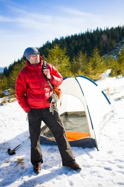 Турист стоит рядом с палаткой . — стоковое фото