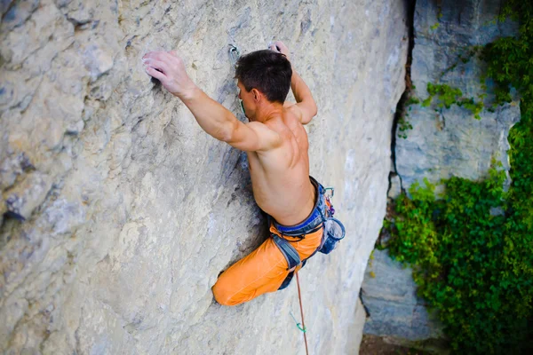 Male sports and climbs on the rock. — Stock Photo, Image