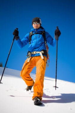 Dağcı karlı bir yamaçta yürür.