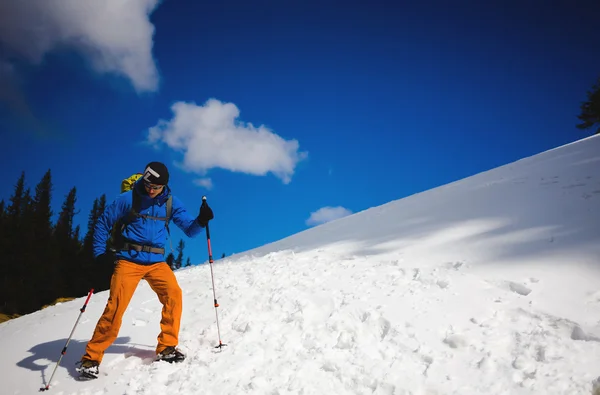 Alpinista idzie na zaśnieżonym stoku. — Zdjęcie stockowe