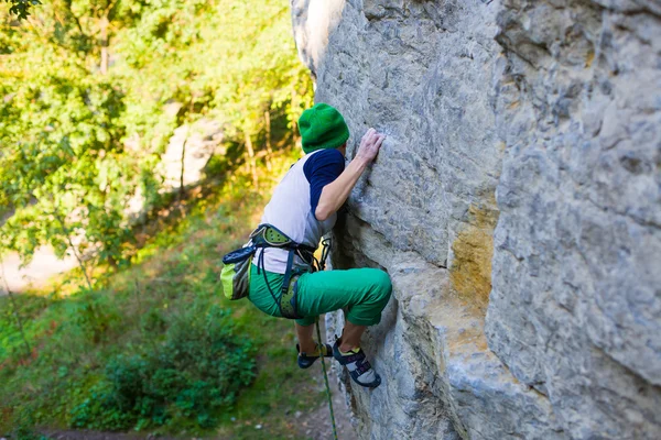 Das Mädchen erklimmt den Felsen. — Stockfoto