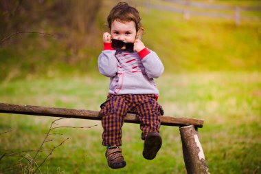 Ellerinde gözlüklü küçük bir çocuk portresi.