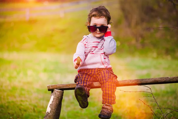Retrato de uma criança com óculos nas mãos . — Fotografia de Stock
