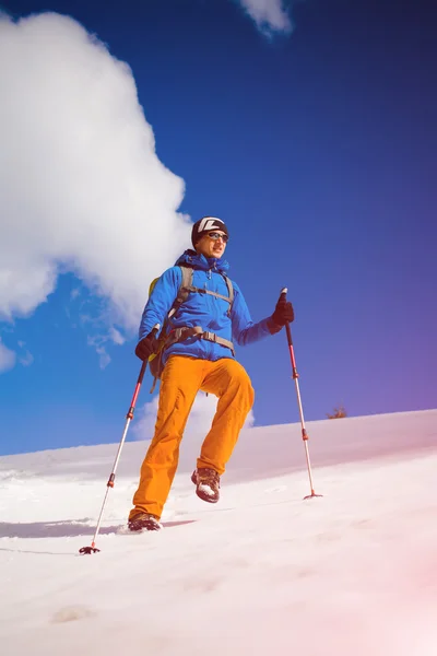 Alpinista idzie na zaśnieżonym stoku. — Zdjęcie stockowe