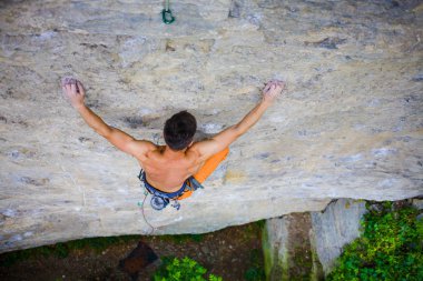 Erkek spor ve kayada tırmanıyor.