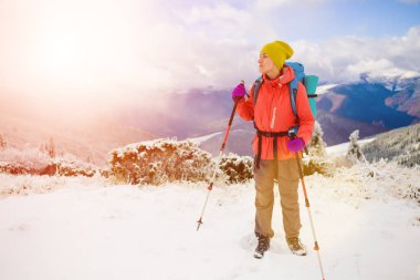 Dağlarda kar üzerinde yürüyen sırt çantası ile kız.