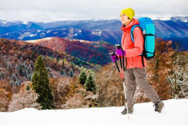 Dağlarda kar üzerinde yürüyen sırt çantası ile kız.