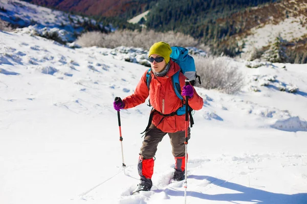 Menina com mochila andando na neve nas montanhas . — Fotografia de Stock