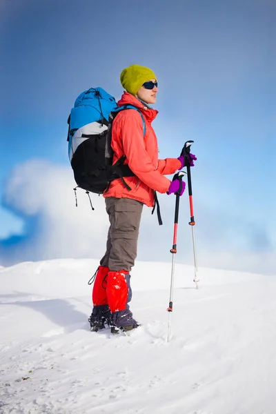Girl with backpack walking on snow in the mountains. — Stock Photo, Image