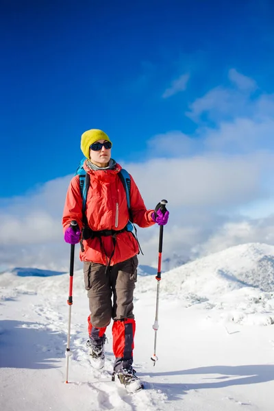 Menina com mochila andando na neve nas montanhas . — Fotografia de Stock