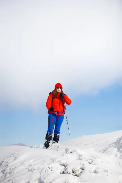 Fille avec sac à dos marchant sur la neige dans les montagnes . — Photo