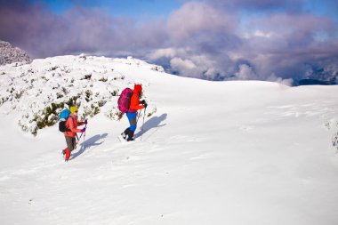 Dağcılar kar yamaçta vardır.