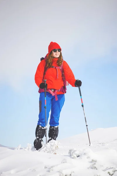 Chica con mochila caminando en la nieve en las montañas . — Foto de Stock