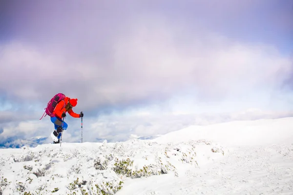 Κορίτσι με σακίδιο περπάτημα στο χιόνι στα βουνά. — Φωτογραφία Αρχείου