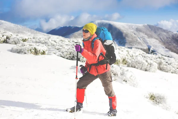 Menina com mochila andando na neve nas montanhas . — Fotografia de Stock