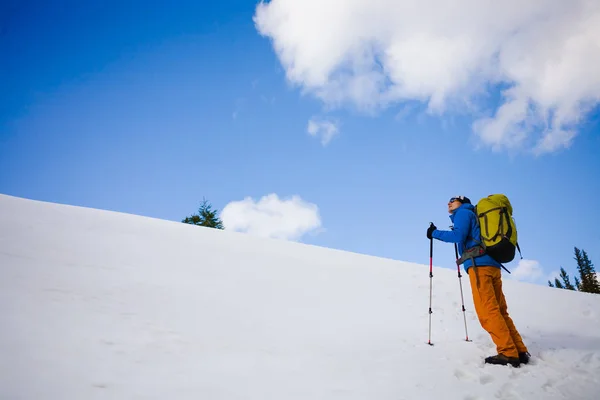 Alpiniste marche sur une pente enneigée . — Photo