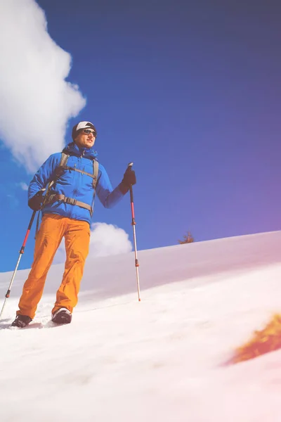 Alpinista idzie na zaśnieżonym stoku. — Zdjęcie stockowe