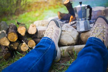 Ateşin yanında oturan insanlar.