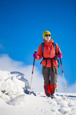 Dağlarda kar üzerinde yürüyen sırt çantası ile kız.