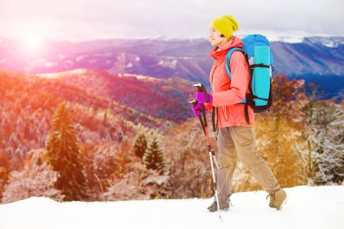 Dağlarda kar üzerinde yürüyen sırt çantası ile kız.