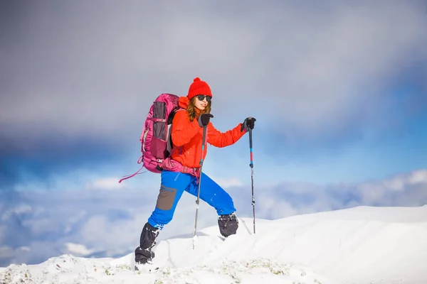 Chica con mochila caminando en la nieve en las montañas . —  Fotos de Stock