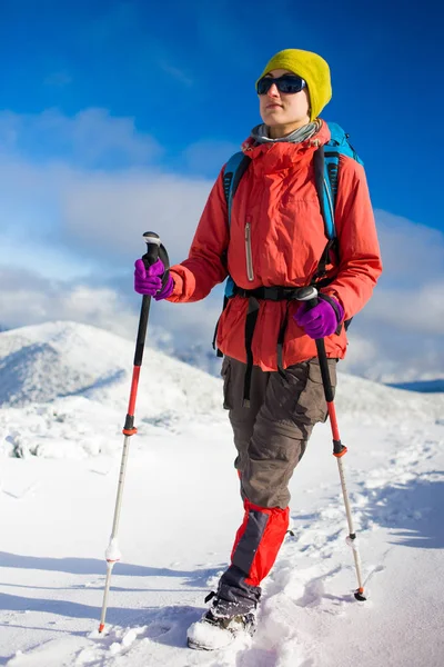 Mädchen mit Rucksack auf Schnee in den Bergen. — Stockfoto