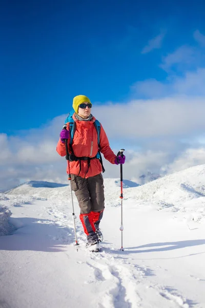 Gadis dengan ransel berjalan di atas salju di pegunungan . — Stok Foto