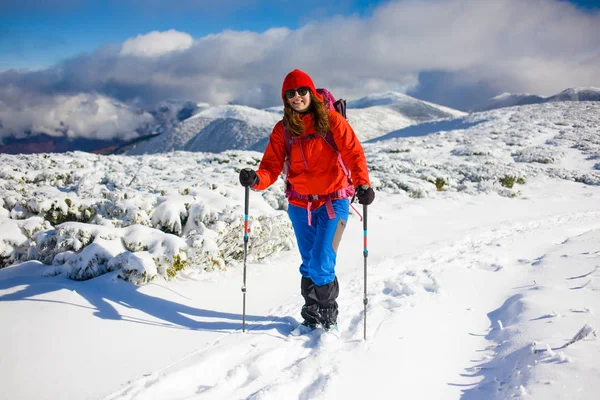 Menina com mochila andando na neve nas montanhas . — Fotografia de Stock