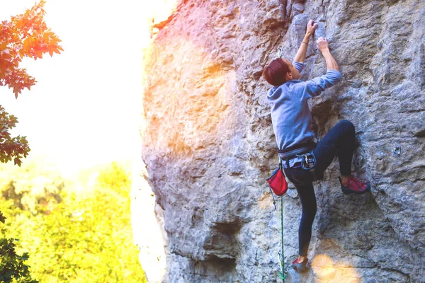 Das Mädchen erklimmt den Felsen. — Stockfoto