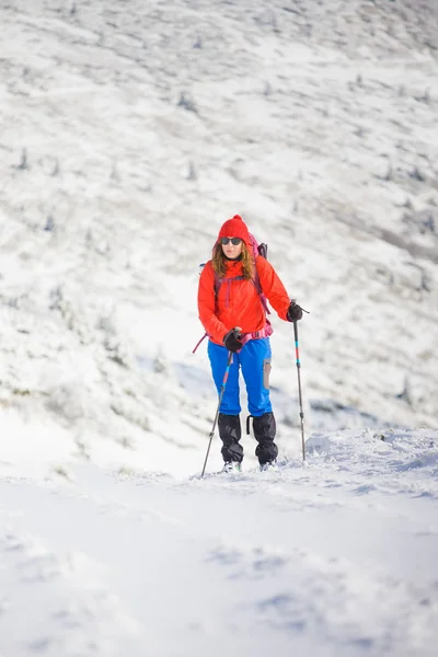 Menina com mochila andando na neve nas montanhas . — Fotografia de Stock