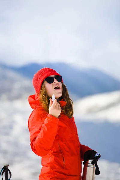 Mädchen genießt einen hygienischen Lippenstift in den Bergen. — Stockfoto