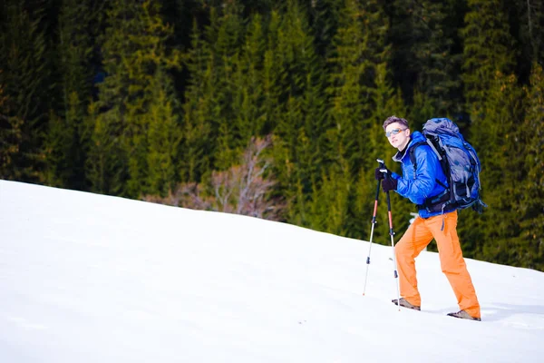 Bergsteiger wandert auf schneebedecktem Hang. — Stockfoto